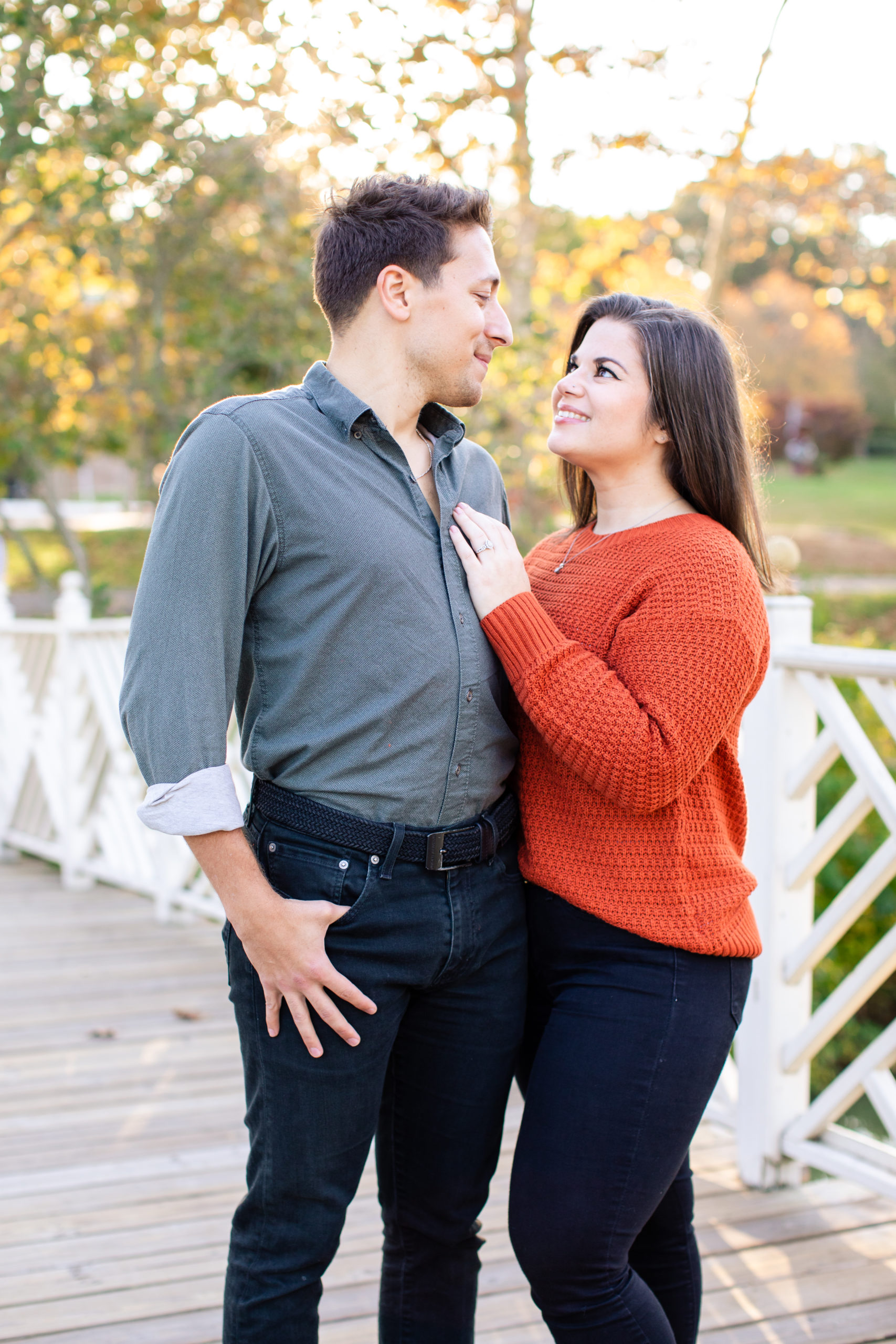 Couple embracing in front of camera during fall engagement session - Luxury Wedding Photographer