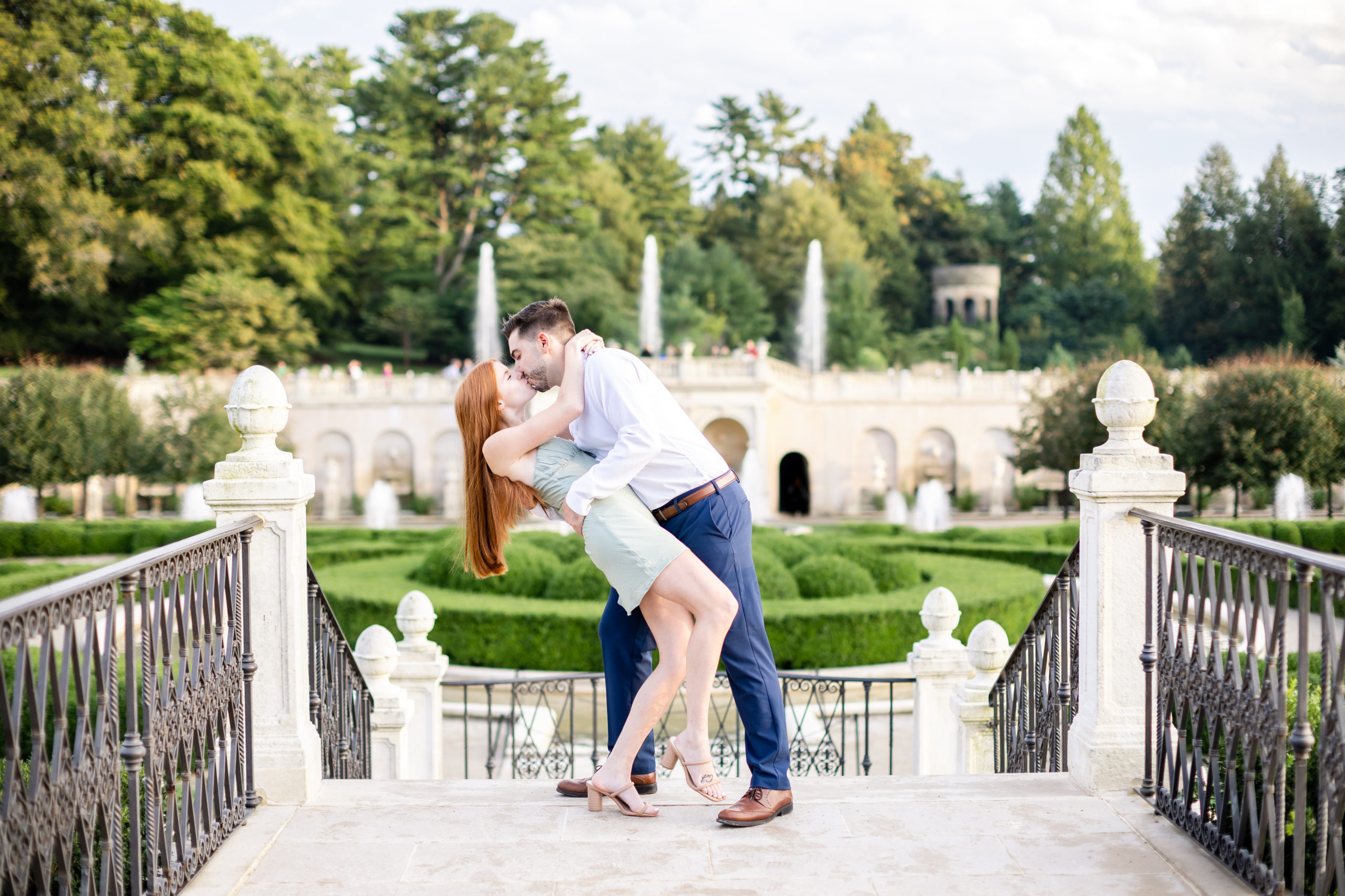 Couple kissing on steps in front of gardens during luxury engagement session at Longwood Gardens - Luxury Wedding Photographer - Wedding Photographer DMV
