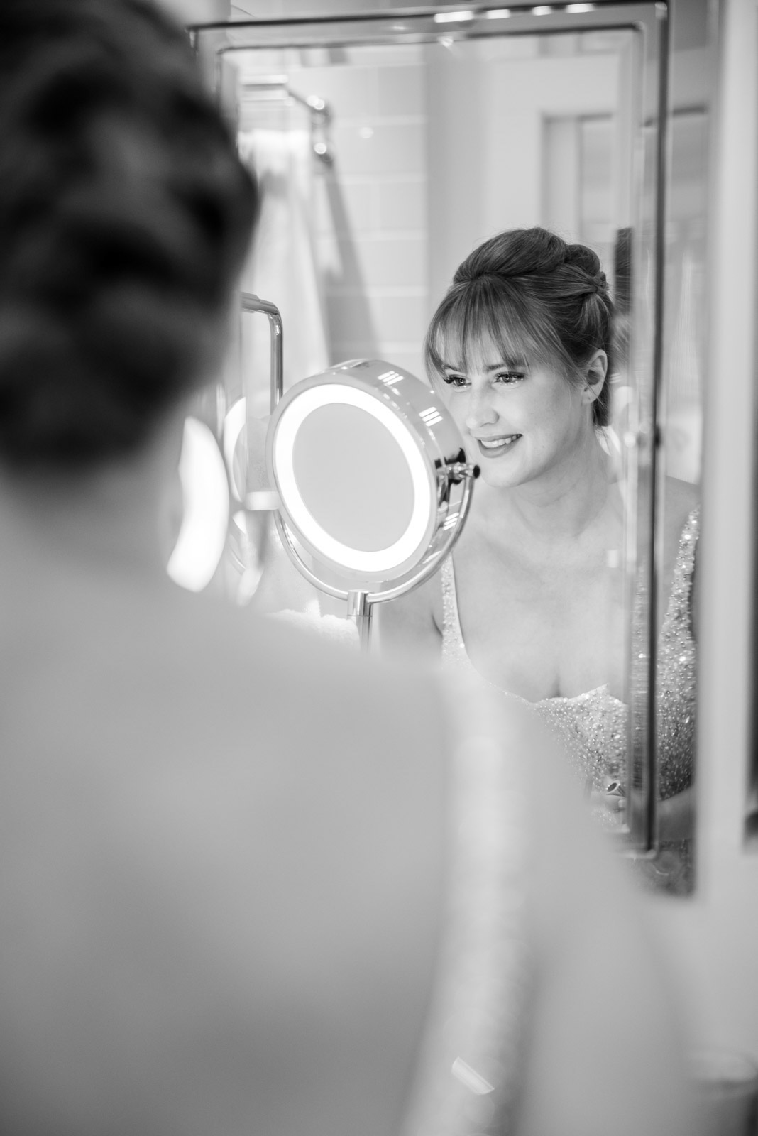 Bride looking into mirror while getting ready for District Winery Wedding