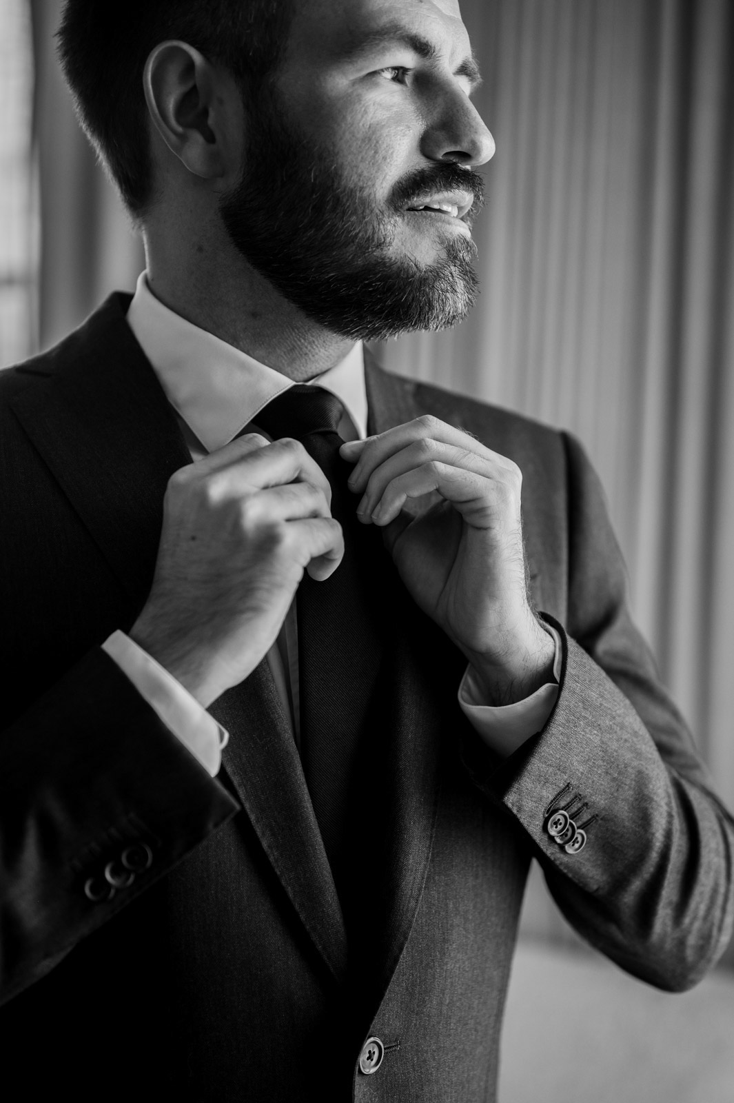 Groom adjusting tie while getting ready for District Winery Wedding