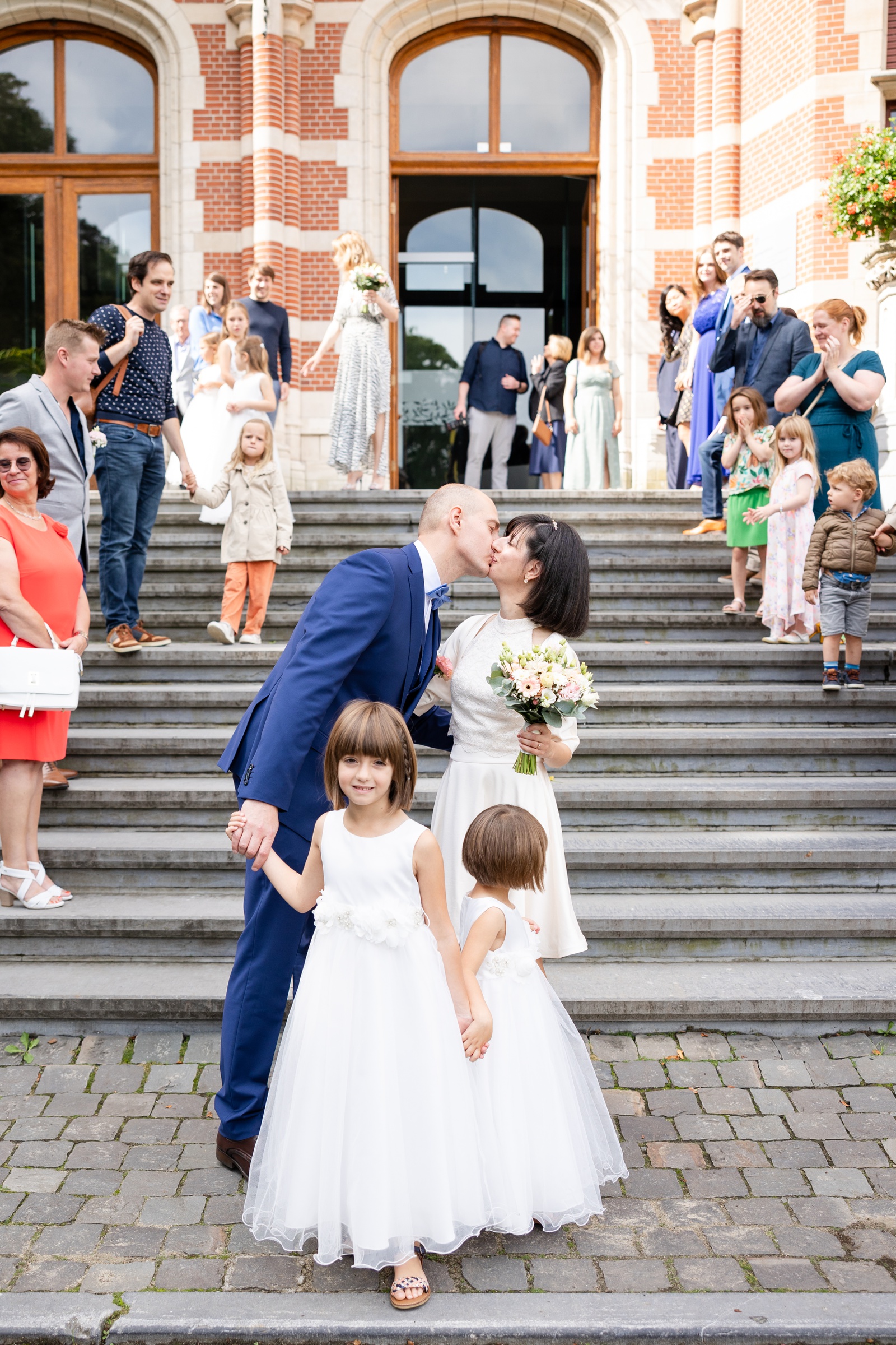 Bride and groom kissing on the steps of the Gemeentehuis Westerlo