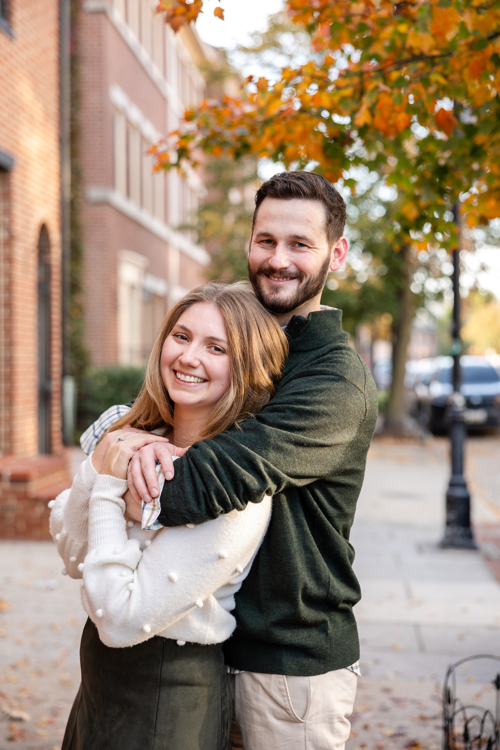 Fall engagement session at Fells Point in Baltimore, with the bride in a white sweater and the groom in a green sweater. 