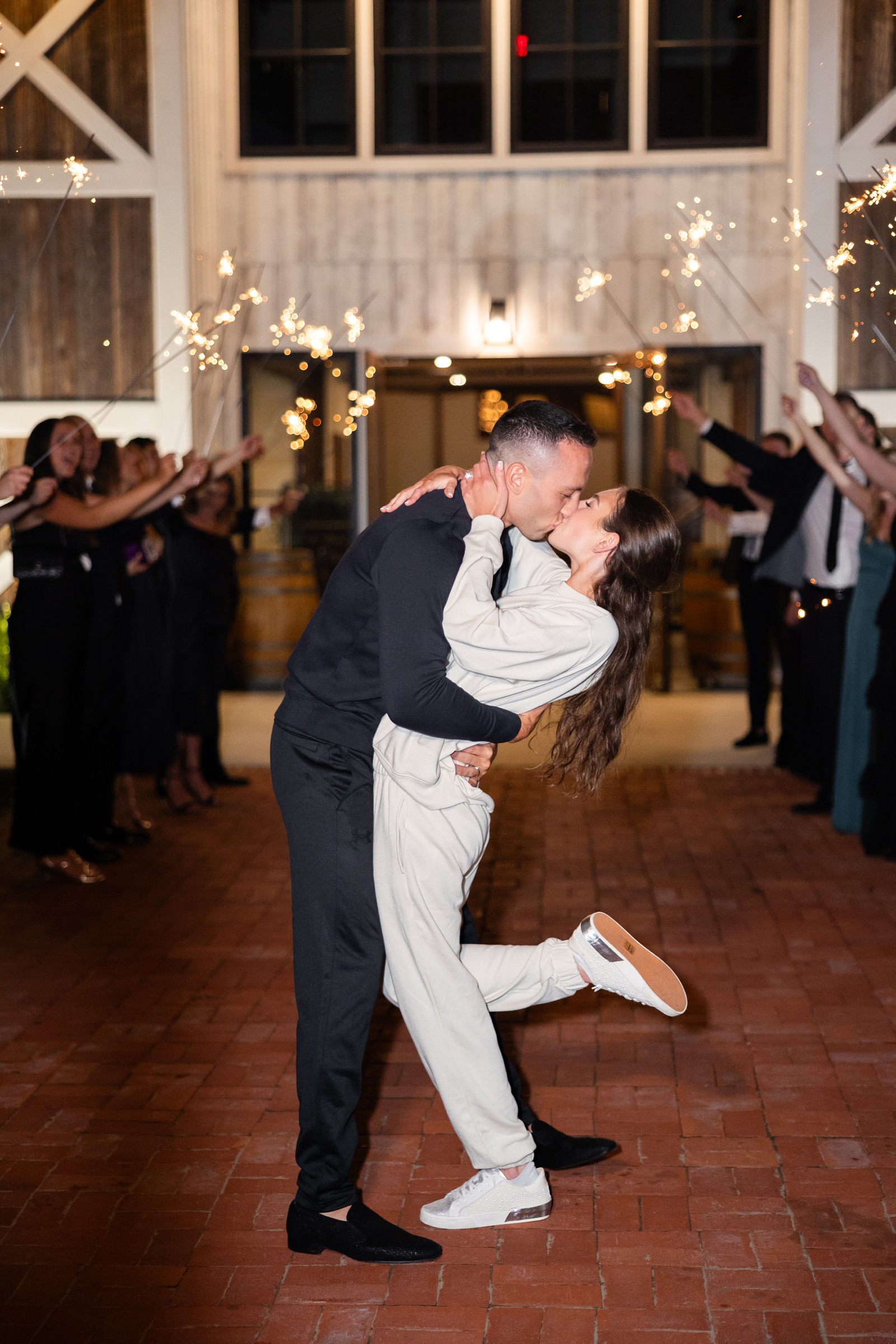 Bride and groom wearing matching sweatsuits for their sparkler wedding exit