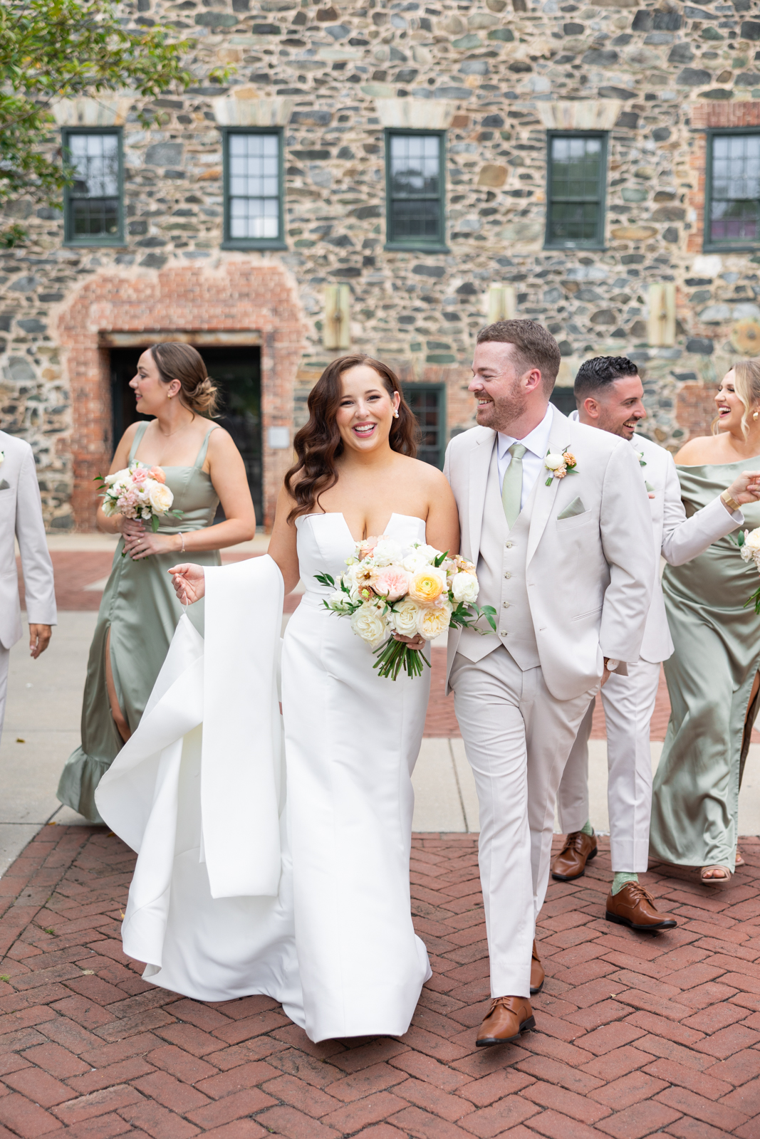 Bride and groom walking with their wedding party outside Mt Washington Mill Dye House in Baltimore