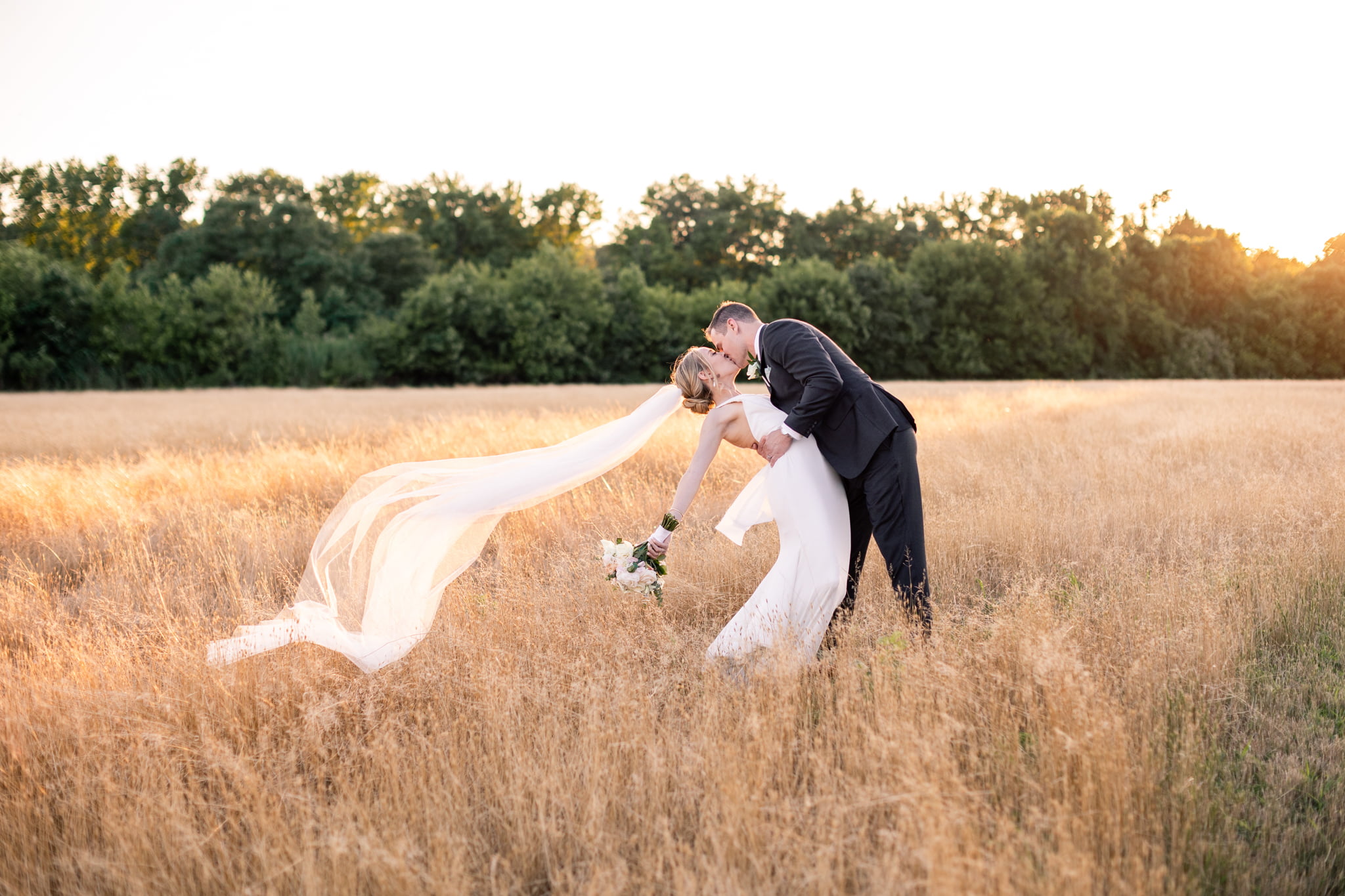 Bride and groom in the sunset field during Kent Island Resort wedding portraits