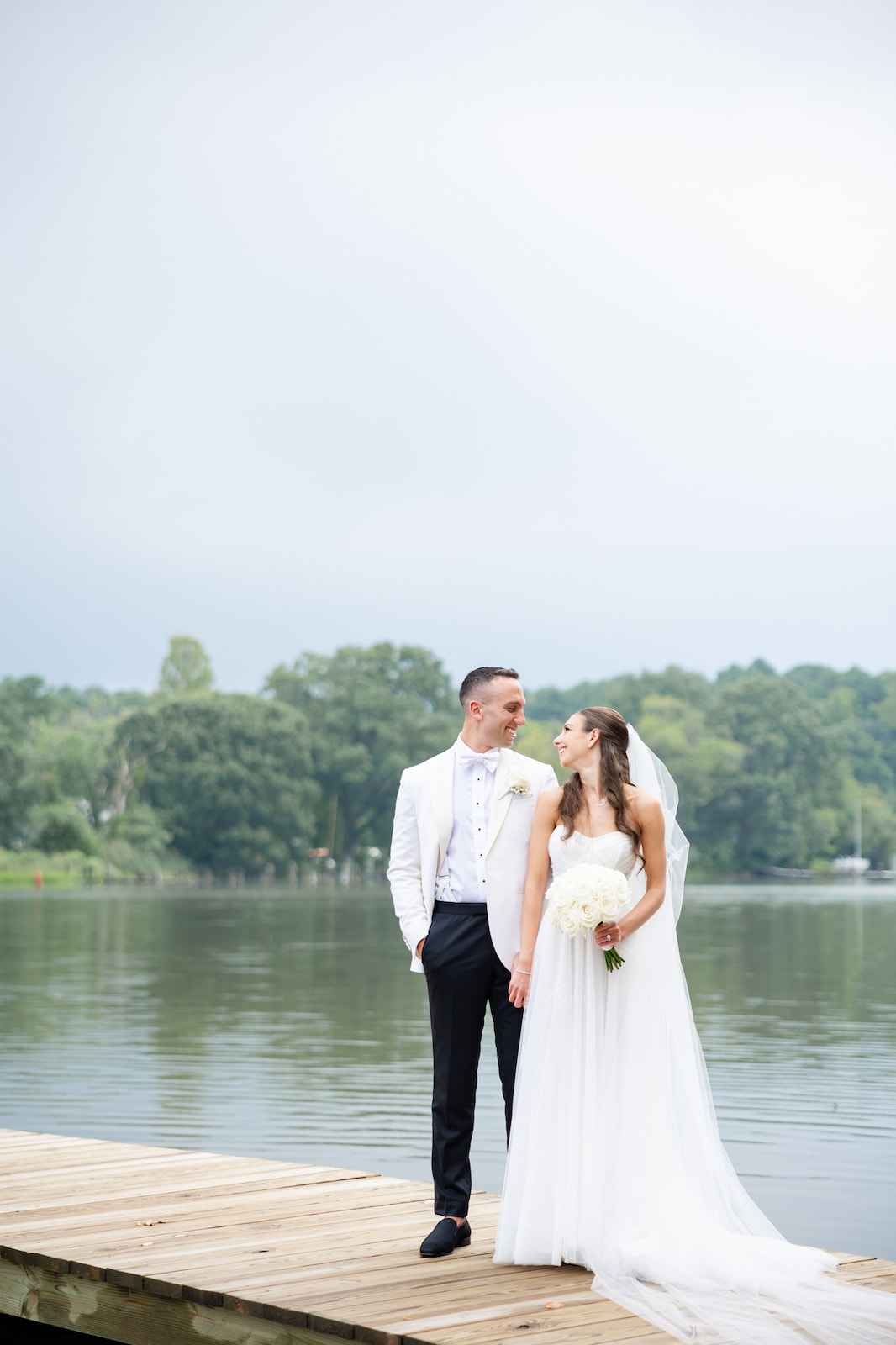 Couple standing on the dock taking wedding portraits at Kent Island Resort